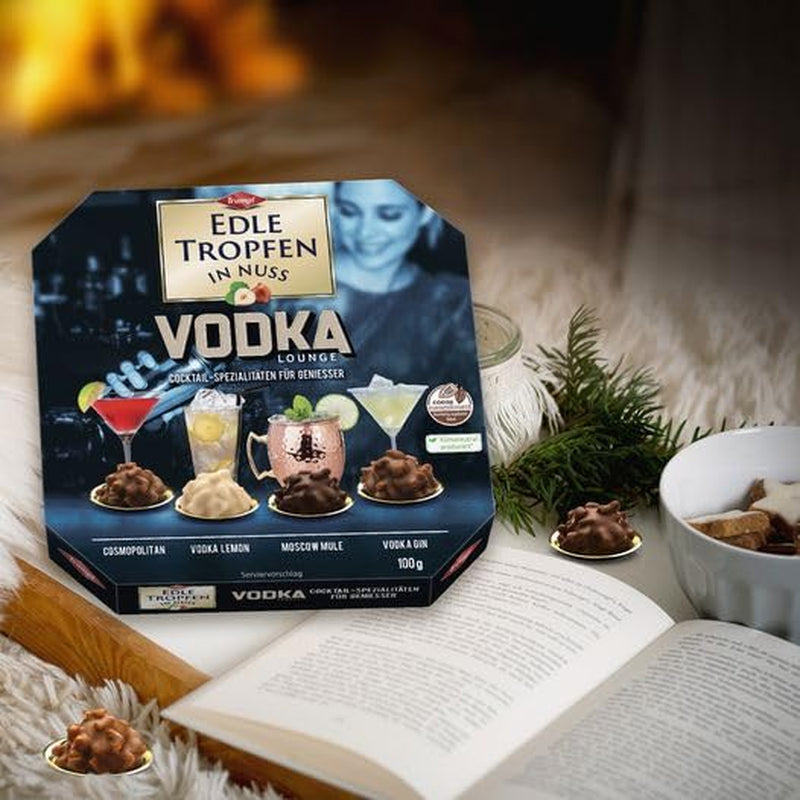 Edle Tropfen în Nuss Vodka Lounge 100g, praline de ciocolată umplute cu lichid, cu glazură de ciocolată cu lapte și bucăți crocante de alune de pădure