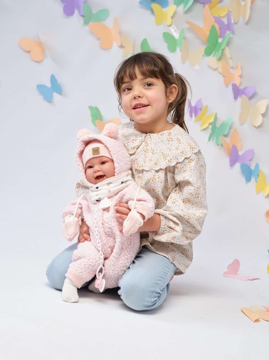 Llorens 1018480 Babypuppe Tala, mit braunen Augen und weichem Körper, Baby Puppe inkl. flauschigem rosa Winter-Outfit, Schnuller, Schnullerkette, 44 cm